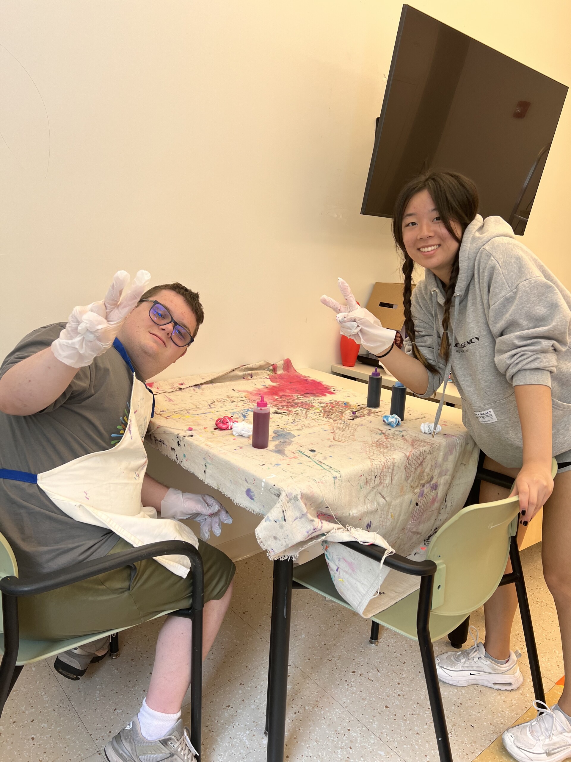 A picture of CEL member with volunteer doing arts and crafts.