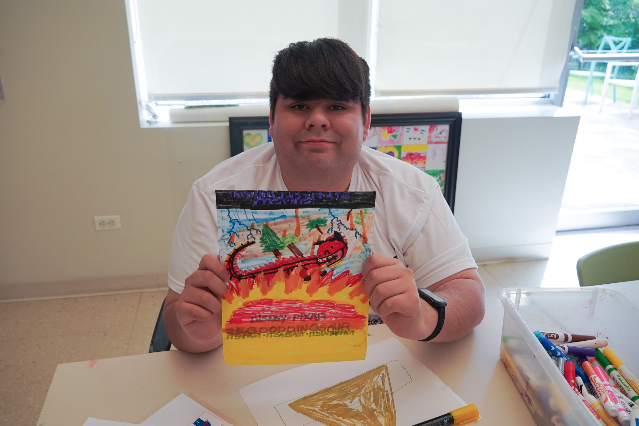 A picture of a REACH CEL member proudly showing their artwork.